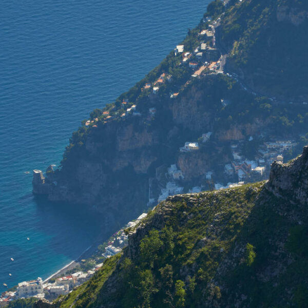 Vue sur la Côte Amalfitaine depuis les hauteurs avec falaises escarpées, villages et mer Méditerranée.