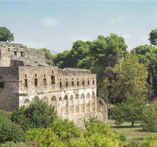 Ruines antiques de Pompéi entourées de verdure.