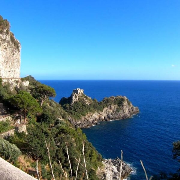 Vue sur Conca dei Marini et la mer de la Côte Amalfitaine, entre falaises, végétation méditerranéenne et eaux bleues.