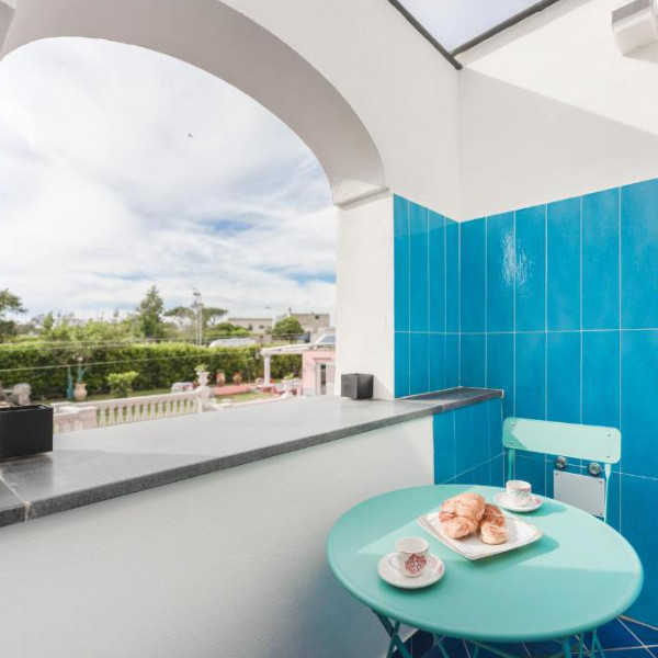 Petit-déjeuner sur un balcon privé avec vue sur le jardin méditerranéen du Corallo Residence.