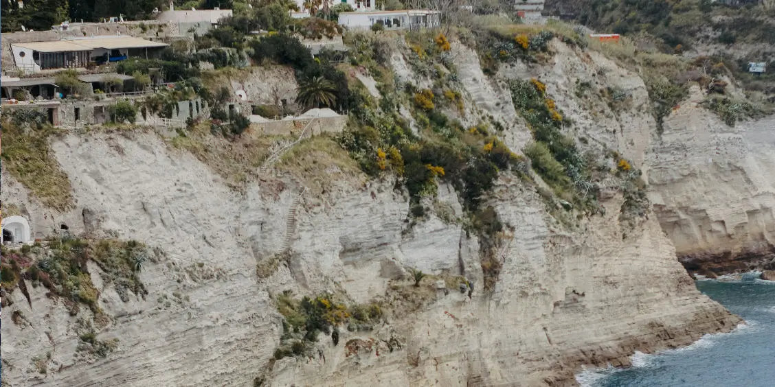 Falaises escarpées et végétation sauvage bordant la côte de l'île d'Ischia.