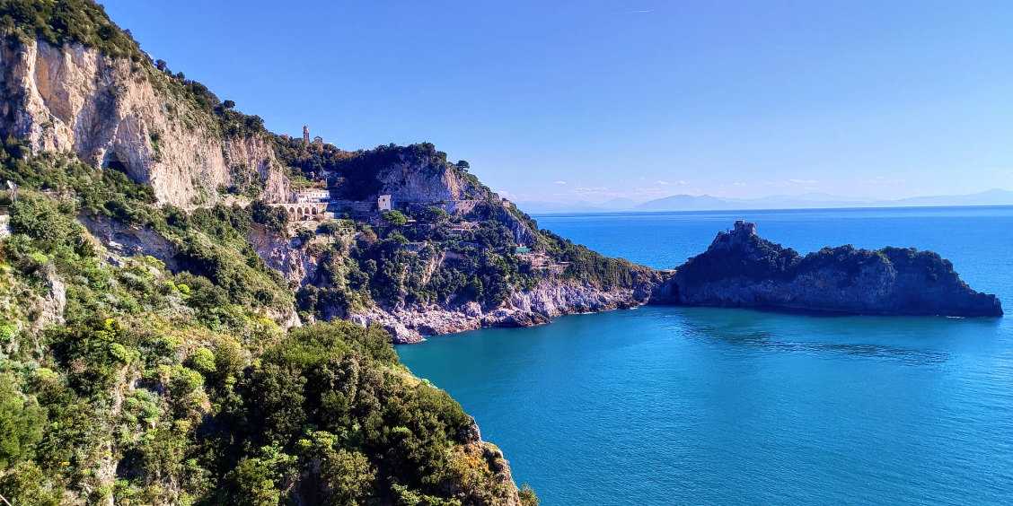 Crique aux eaux turquoise et promontoire rocheux sur le littoral de la Côte Amalfitaine.