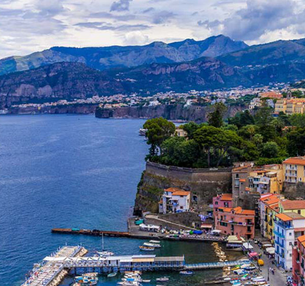 Sorrente en décembre avec Marina Grande, maisons colorées, mer et montagnes en arrière-plan.
