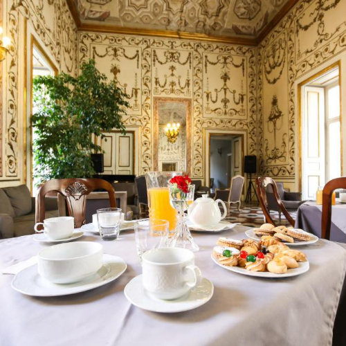 Salle de petit-déjeuner élégante avec décor baroque et service de café et pâtisseries.