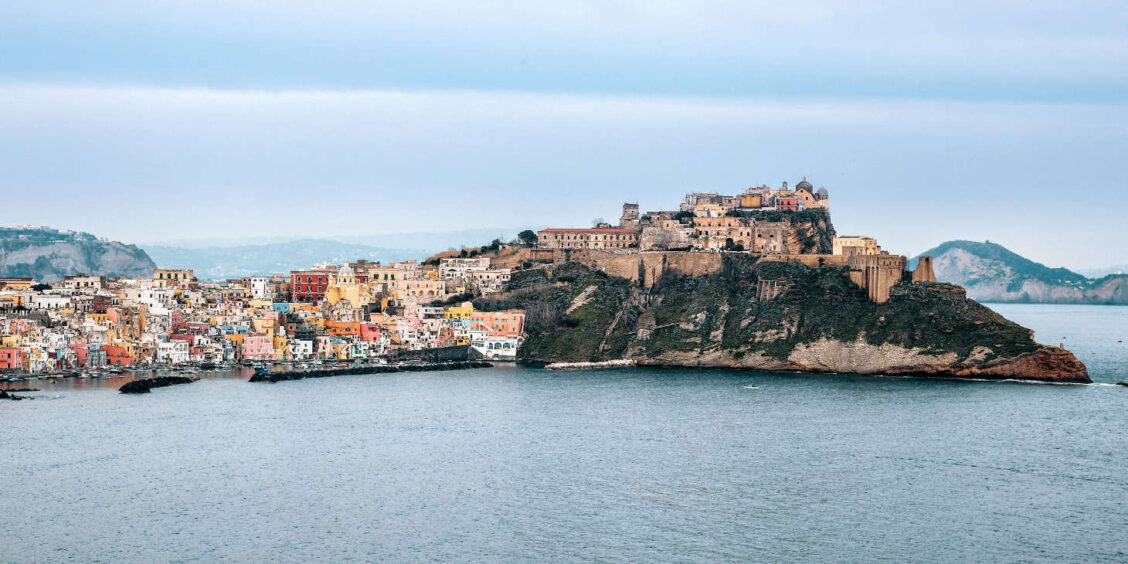 Panorama de Procida mettant en valeur Terra Murata et les maisons pastel de Marina Corricella, Campanie.