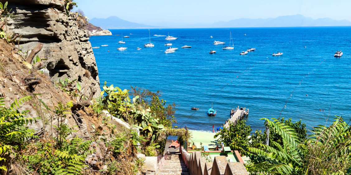 Vue sur la plage de la Chiaia à Procida avec ses bateaux et sa végétation méditerranéenne.