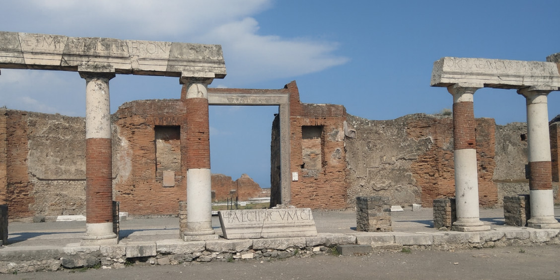 Vestiges de l'édifice d'Eumachia à Pompéi avec ses colonnes et ses inscriptions antiques.