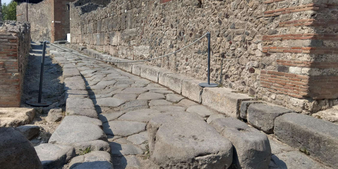 Vue d'une voie romaine authentique avec ses dalles de pierre et ses murs de briques à proximité de la Domus de Romulus et Rémus.