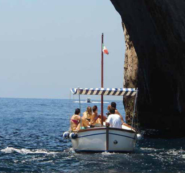 Excursion en bateau depuis Sorrente avec passage sous une arche rocheuse en mer.