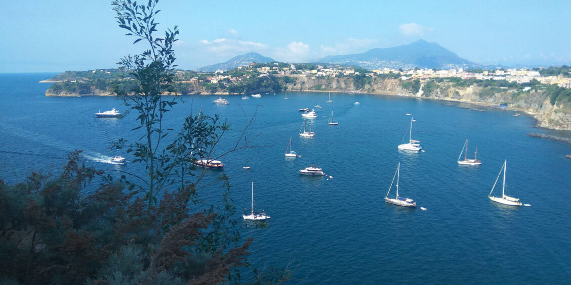 Excursion en bateau à Procida : voiliers et yachts au mouillage dans les eaux cristallines de la Campanie.
