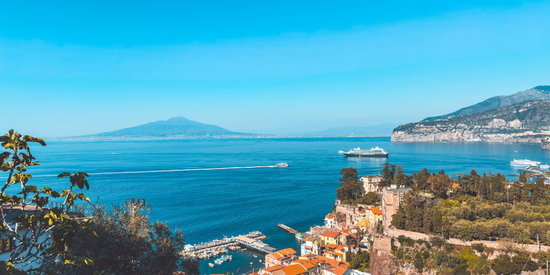 Paysage de la côte de Sorrente surplombant la mer Méditerranée, avec vue sur le volcan Vésuve et le port.