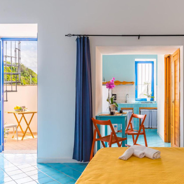Intérieur lumineux au style méditerranéen avec carrelage bleu et coin cuisine ouvert.