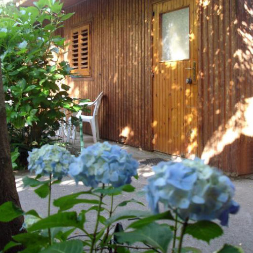 Bungalow en bois du Fiori d’Arancio à Sorrente avec fleurs et terrasse ombragée.