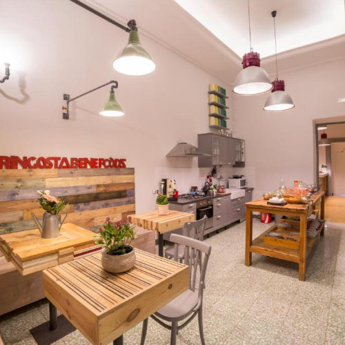 Cuisine et salle à manger conviviale à Naples avec tables en bois et espace partagé.