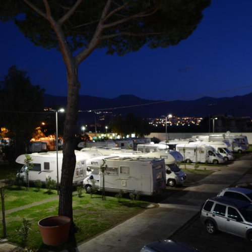 Aire de camping-car du Fortuna Village Pompei illuminée de nuit.
