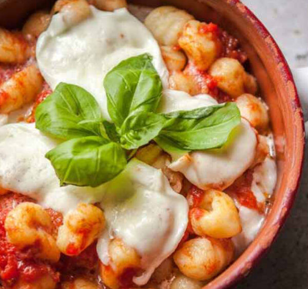 Gnocchis à la sorrentina avec sauce tomate, mozzarella fondue et basilic, spécialité italienne traditionnelle.