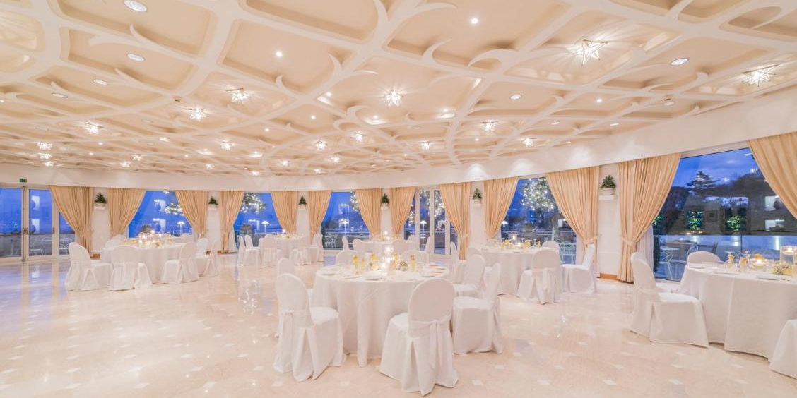 Grande salle panoramique du restaurant du Grand Hotel Aminta à Sorrente avec tables élégamment dressées.