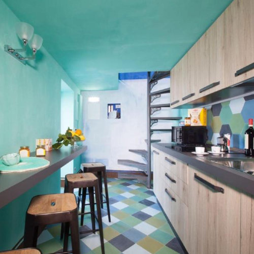 Cuisine de Grotta Azzurra à Sorrente avec comptoir, escalier et décoration turquoise.