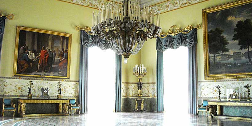 Intérieur somptueux d'une salle du Palais Royal de Capodimonte à Naples, orné d'un lustre monumental, de peintures de maître et de mobilier historique.