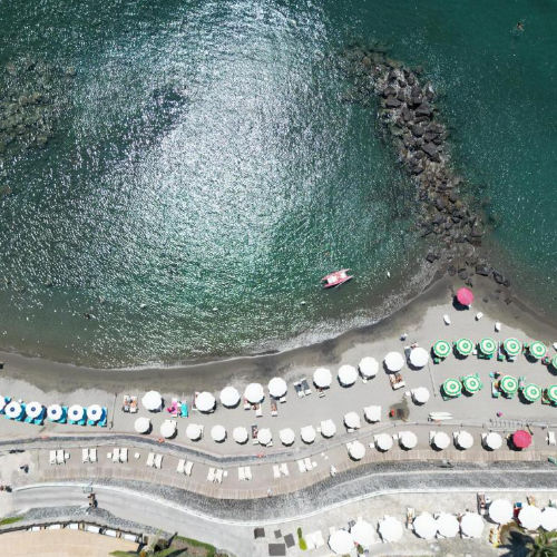 Vue aérienne de la plage privée de l'hôtel avec ses alignements de parasols.