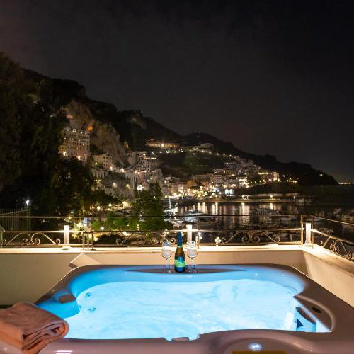 Jacuzzi panoramique de l’Hotel Aurora à Amalfi avec vue nocturne sur la côte.