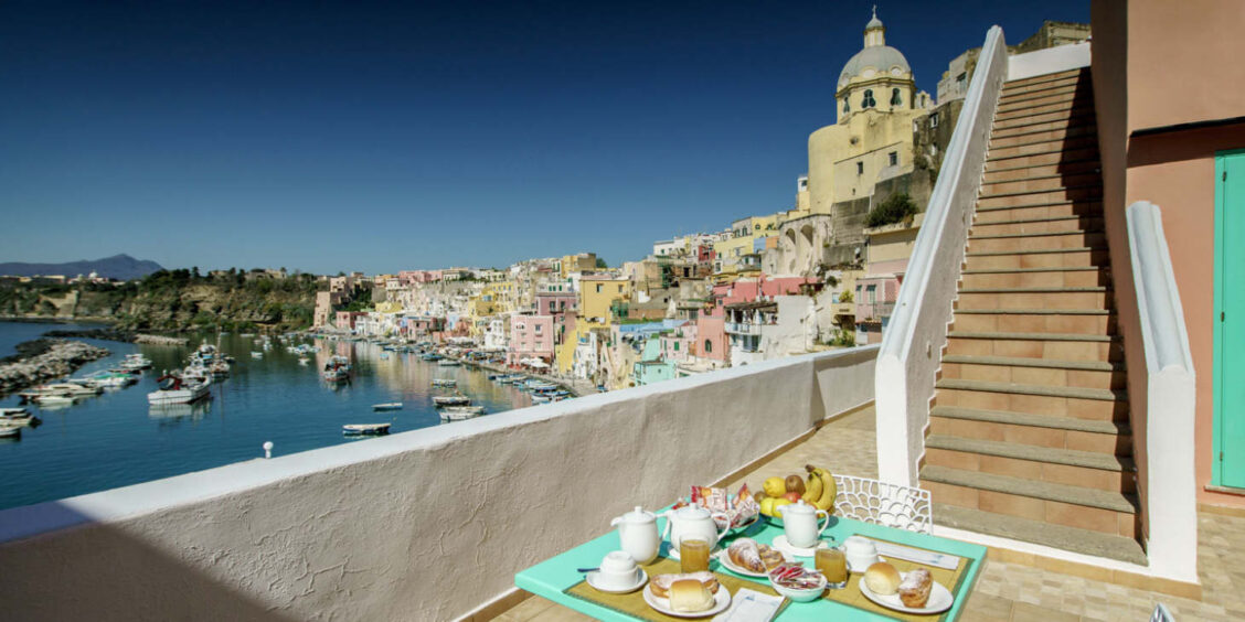 Terrasse de petit déjeuner avec vue imprenable sur le port et l'église de Procida, Campanie.