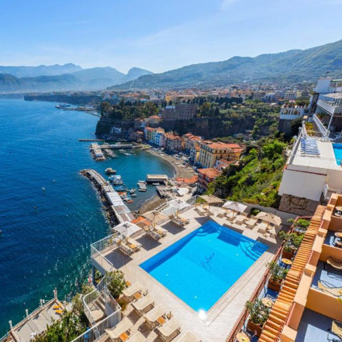 Piscine de l’Hotel Belair à Sorrente avec vue panoramique sur la mer et le port.