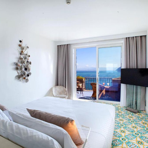 Chambre de l’Hotel Belair à Sorrente avec balcon privé et vue sur la mer.