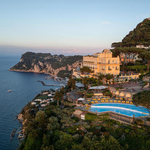 Vue aérienne de l'Hôtel Caesar Augustus à Capri, niché sur une falaise avec piscine et panorama sur la mer.