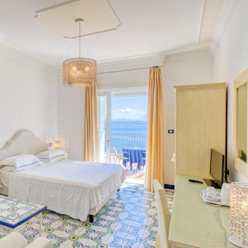Chambre élégante de l'Hôtel Cetus avec carrelage traditionnel et balcon offrant une vue mer.