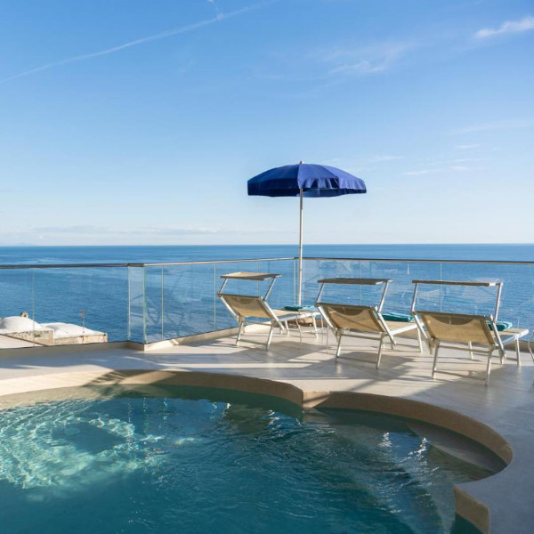 Piscine panoramique de l’Hotel Eden Roc à Positano avec transats et vue sur la mer.