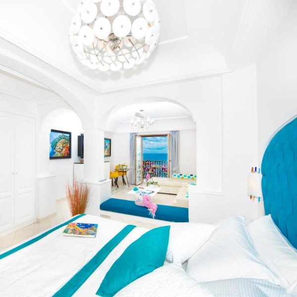Suite lumineuse de l’Hotel Eden Roc à Positano avec balcon vue mer.