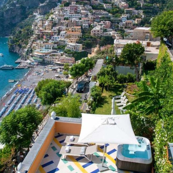 Terrasse de l’Hotel Eden Roc à Positano avec jacuzzi et vue sur la plage.