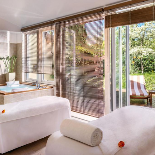 Salle de soins de l’Hotel Excelsior Vittoria à Sorrente avec lits de massage et vue sur le jardin.