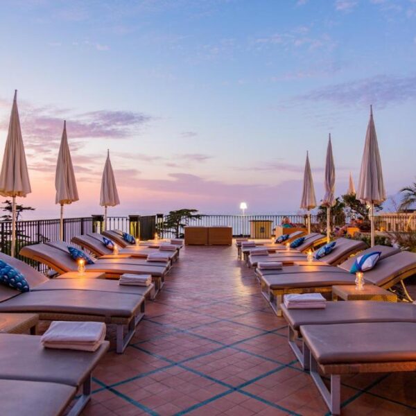 Solarium panoramique de l’Hôtel Bristol à Sorrente avec transats, parasols et ambiance au coucher du soleil.
