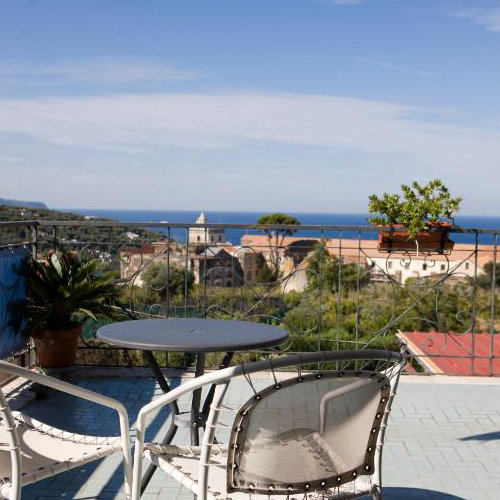 Terrasse de l’Hotel La Primavera à Massa Lubrense avec table, chaise et panorama côtier.