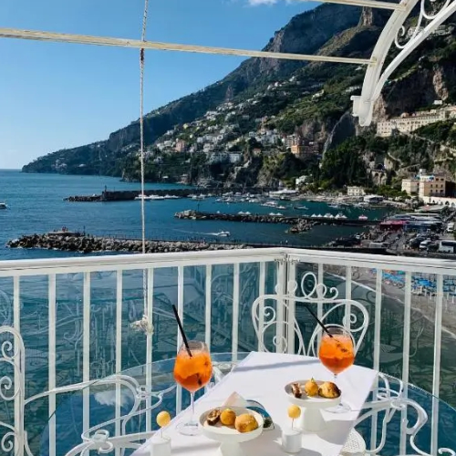 Apéritif face à la mer avec cocktails Spritz sur la terrasse panoramique de l'hôtel.