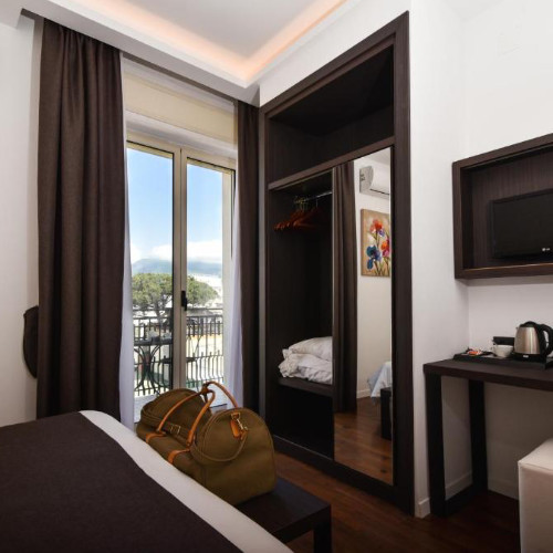 Chambre moderne de l'Hôtel Palma avec mobilier sombre et balcon privé.