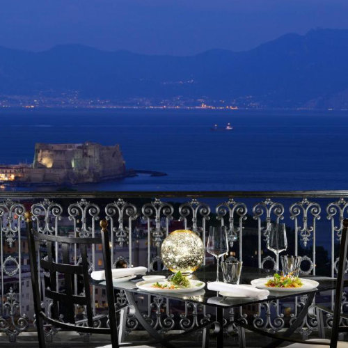 Dîner avec vue sur le Castel dell’Ovo depuis le Grand Hotel Parker’s à Naples au coucher du soleil.