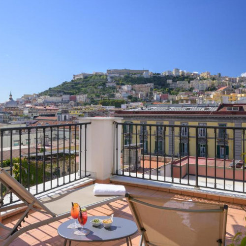 Terrasse de l’Hotel Piazza Bellini à Naples avec vue sur la ville et colline du Vomero.