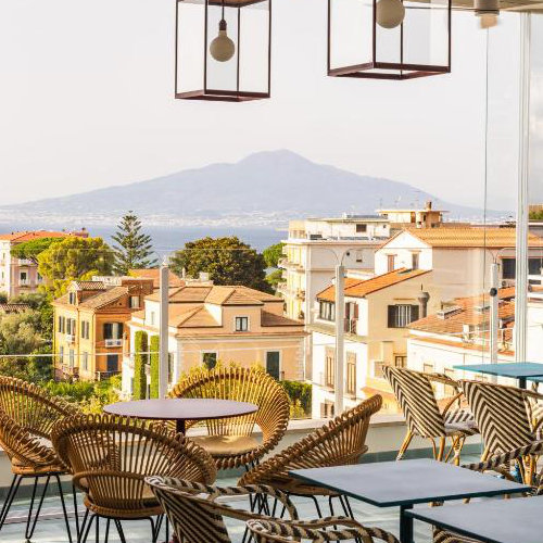Terrasse de l’Hotel Plaza Sorrento avec vue sur les toits et le Vésuve.