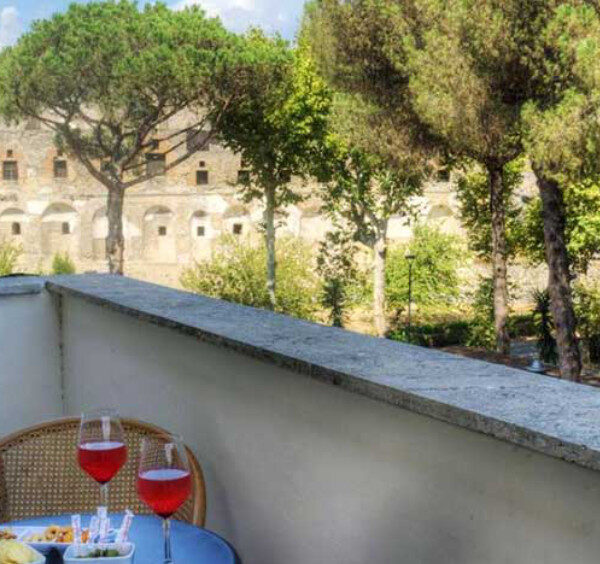 Balcon avec vue sur les ruines de Pompéi et apéritif en terrasse.