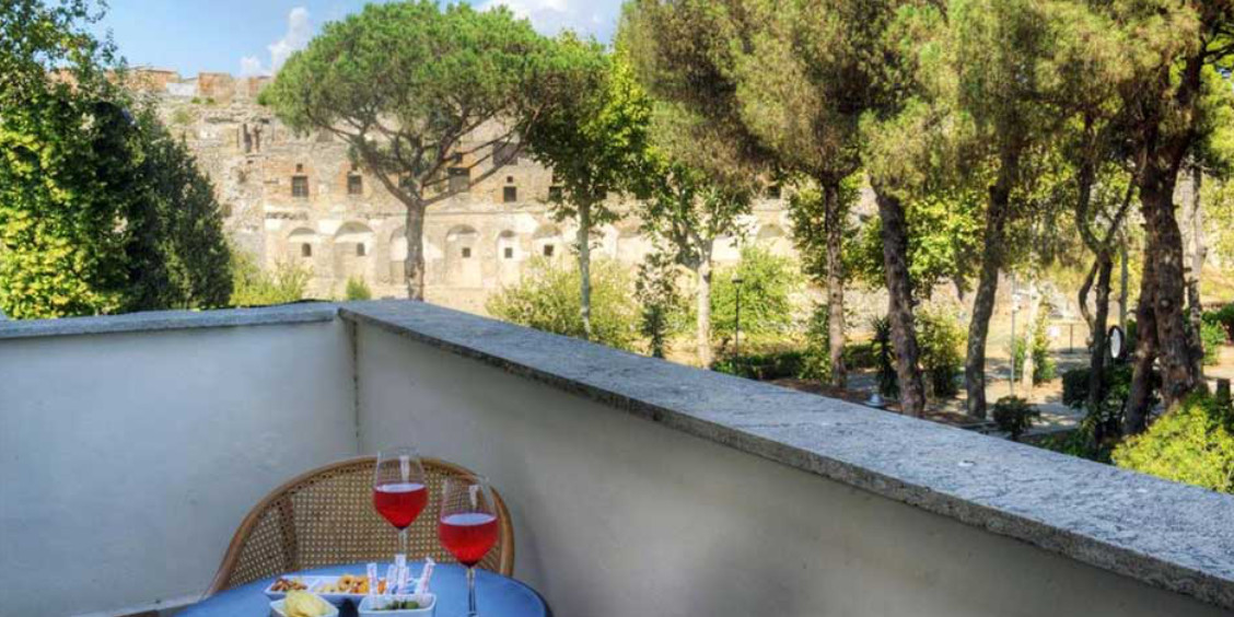 Balcon avec vue sur les ruines de Pompéi et apéritif en terrasse.