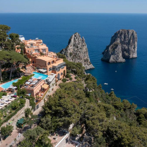 Vue aérienne de l'hôtel Punta Tragara à Capri face aux célèbres rochers Faraglioni et à la mer.
