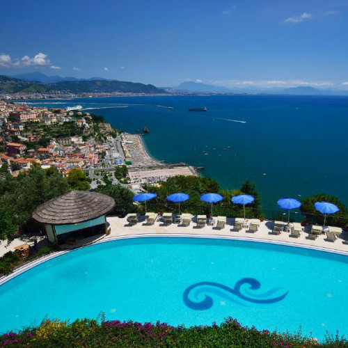 Piscine panoramique de l'Hôtel Raito avec parasols bleus face au golfe de Salerne.