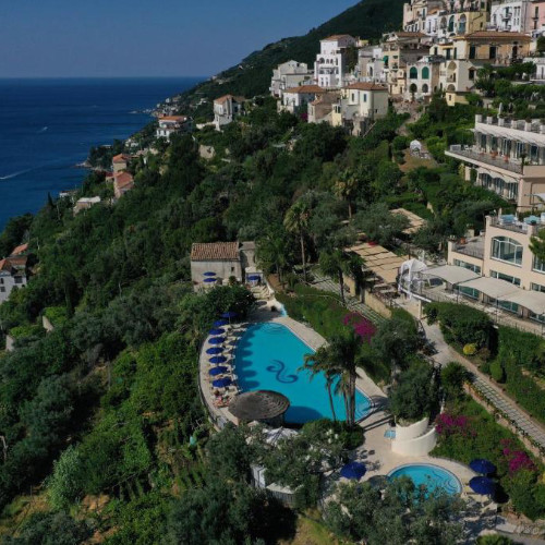 Vue aérienne de l'Hôtel Raito niché sur la colline avec ses piscines et jardins.