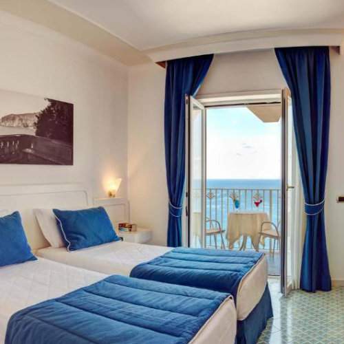 Chambre de l’Hotel Riviera à Sorrente avec balcon privé et vue sur le golfe.