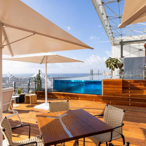 Terrasse avec piscine panoramique de l’Hotel Romeo à Naples avec vue sur le port.