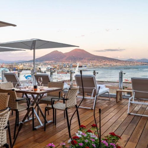 Restaurant panoramique de l’Hotel Romeo à Naples avec vue sur le Vésuve et la baie.