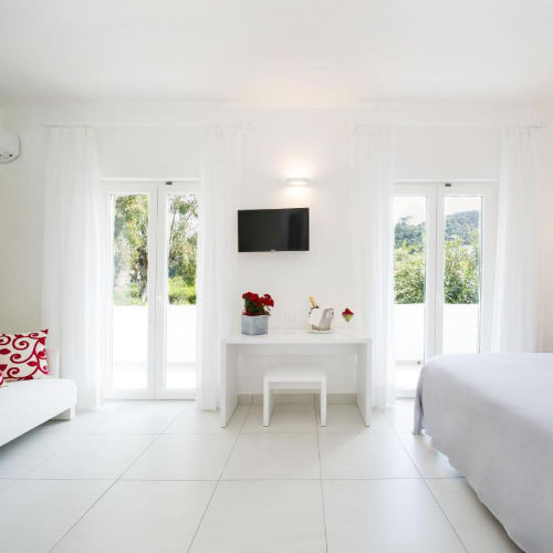Chambre d'hôtel spacieuse et lumineuse au design minimaliste blanc.